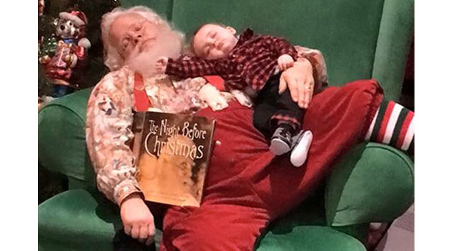 Santa reads baby to sleep.